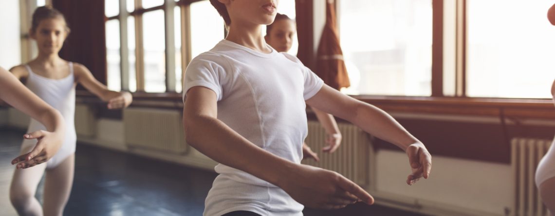 Young male dancer in ballet class wearing attire needed for class