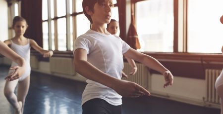 Young male dancer in ballet class wearing attire needed for class