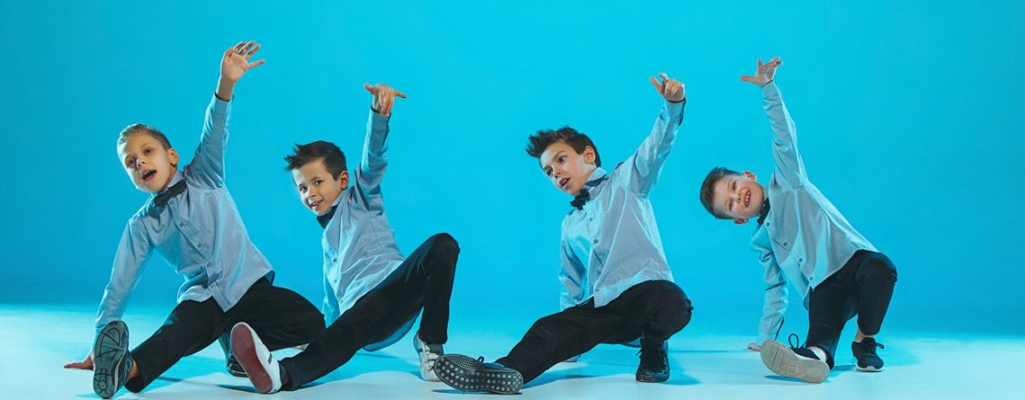 Four young boys perform a hip hop dance routine, showing their strength a benefit of taking dance classes