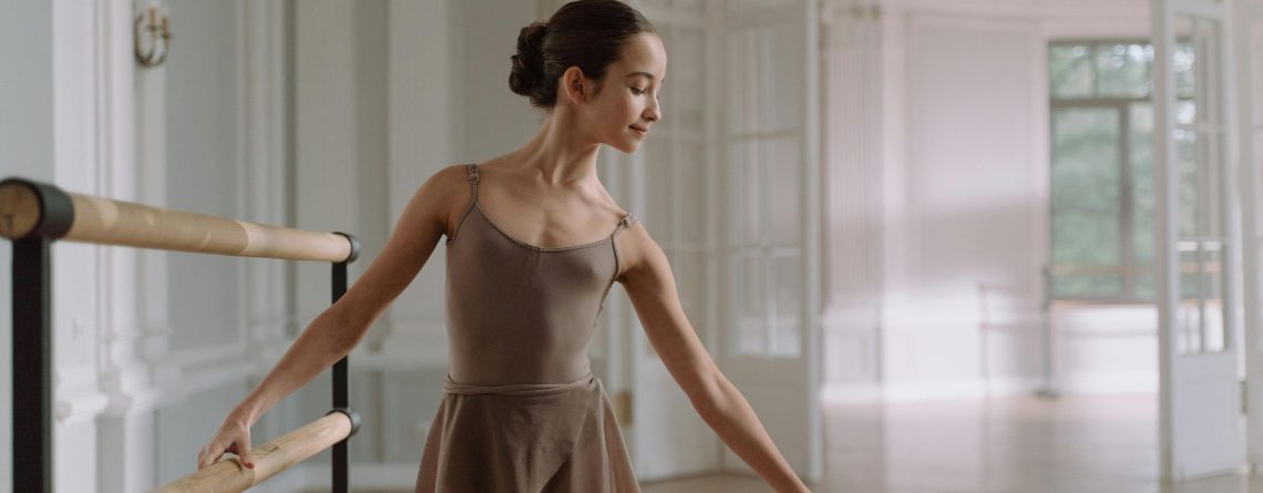 Ballerina at the ballet barre dressed in a leotard and tights