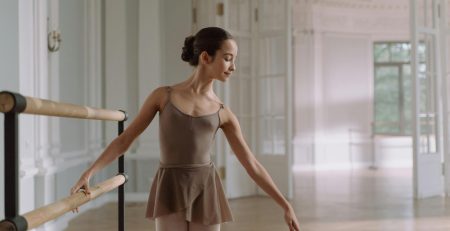 Ballerina at the ballet barre dressed in a leotard and tights