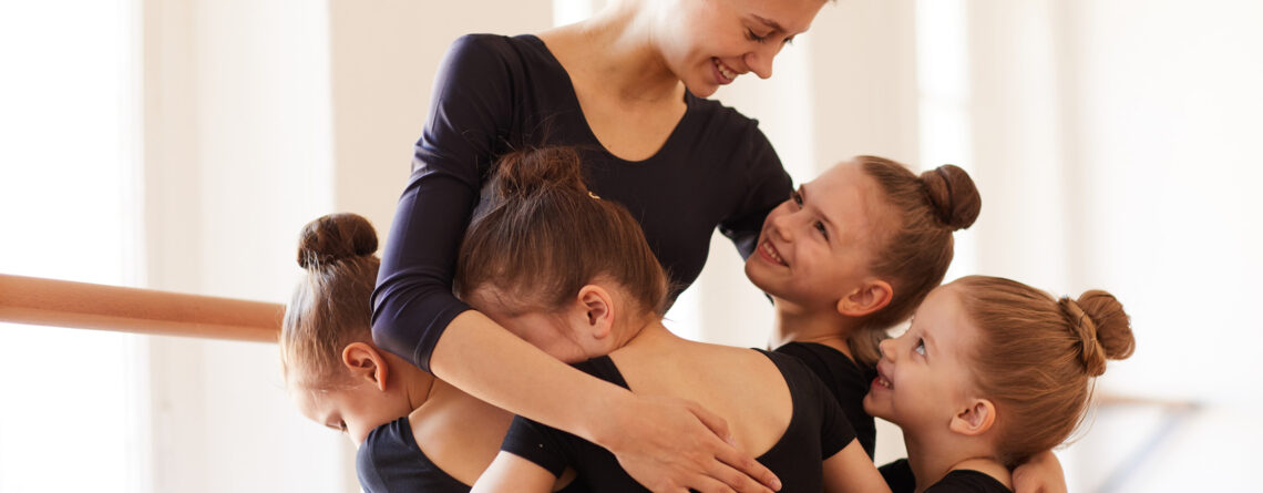 Young dancers hug their beloved dance teacher in their local dance studio