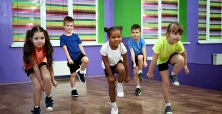 Five young dancers are having fun performing in their hip hop dance class